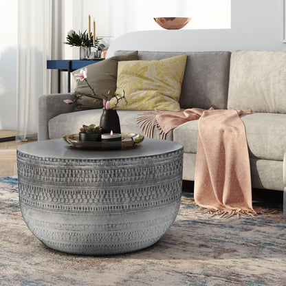 A cozy living room with a light gray sofa, yellow patterned pillow, pink throw blanket, and the Johnsen Handcrafted Metal Coffee Table topped with a decorative tray and flowers, plus a colorful rug on the floor.