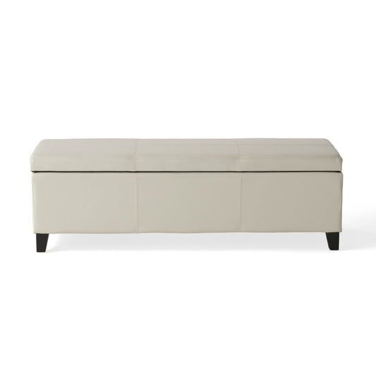 The Glouster - Contemporary Storage Ottoman is a rectangular, light beige bench with a cushioned lid and short dark wooden legs, displayed against a white background.