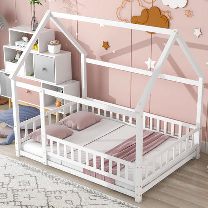 A Floor Wooden Bed With House Roof Frame and fence guardrails, featuring pink and gray bedding, sits in a cozy pink-themed kids' room decorated with star and cloud wall art and a white toy-and-book shelf nearby.