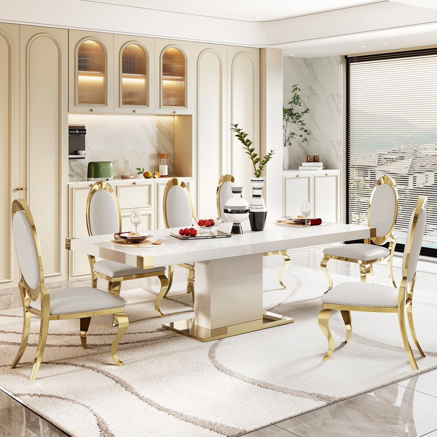 A modern dining room featuring the Top Dining Table With Finish Corner in white and gold marble, six white chairs with gold trim, a beige rug, decorative vases, place settings, and fruit. Large windows fill the space with natural light.
