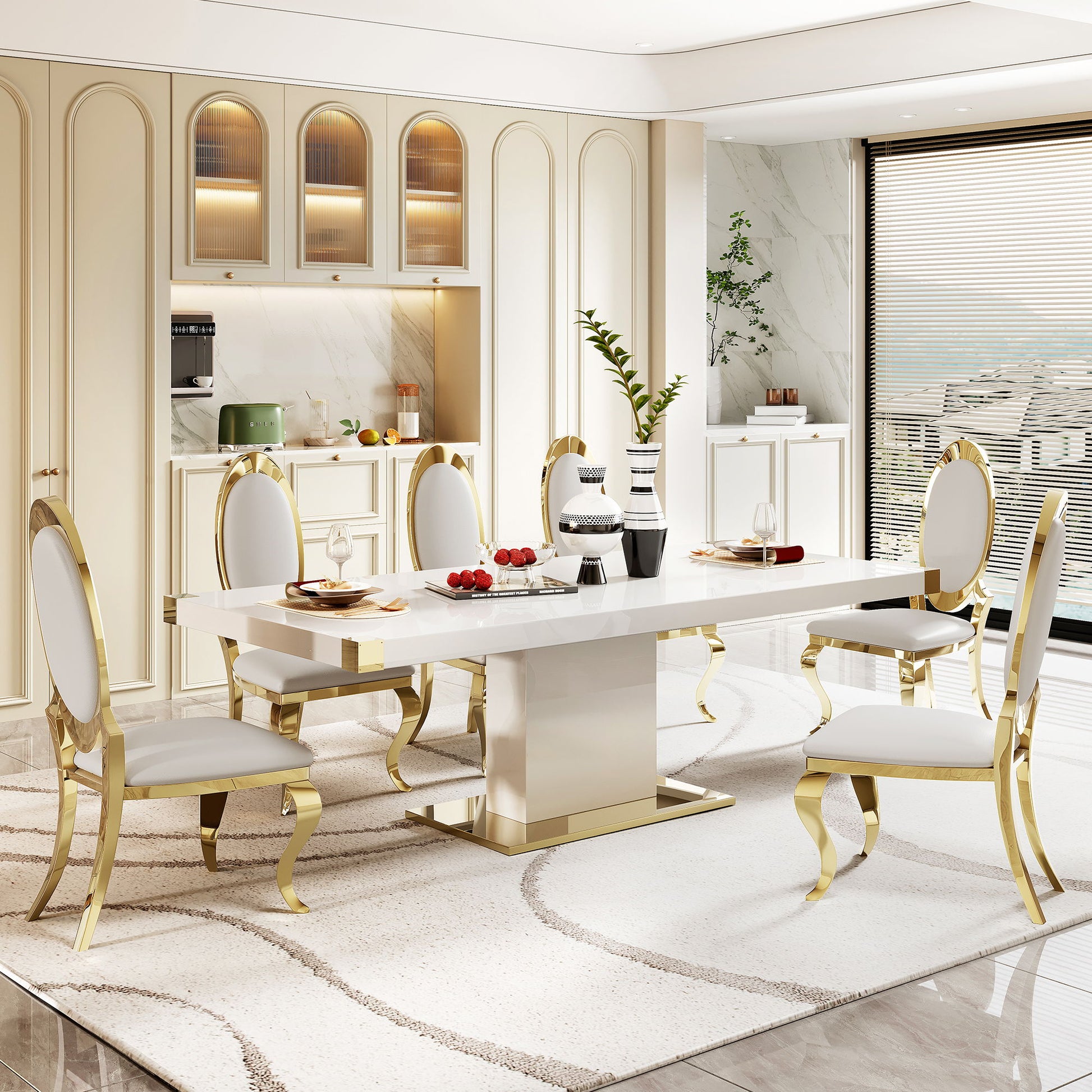 A modern dining room featuring the Top Dining Table With Finish Corner in white and gold marble, six white chairs with gold trim, a beige rug, decorative vases, place settings, and fruit. Large windows fill the space with natural light.