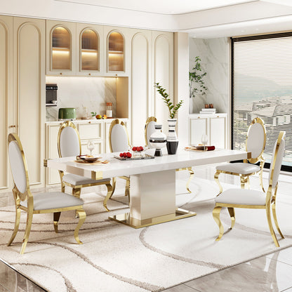 A modern dining room featuring the Top Dining Table With Finish Corner in white and gold marble, six white chairs with gold trim, a beige rug, decorative vases, place settings, and fruit. Large windows fill the space with natural light.