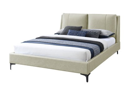 The Fully Upholstered Bed features a tall, padded beige headboard and is styled with white, blue, and gray bedding plus decorative pillows, shown against a white background.