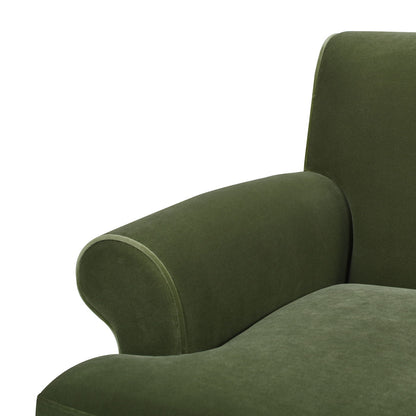 Close-up view of the Alana Lawson - Three Cushion Tightback Sofa in green velvet, showing part of the seat, curved armrest, and a portion of the backrest against a white background.