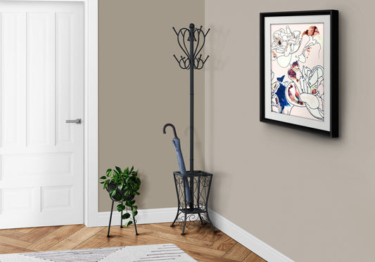 A small entryway features a closed white door, a free-standing black hall tree with 8 hooks and umbrella holder, a potted plant on a stand, and framed abstract floral and human artwork on a taupe wall above wooden flooring.