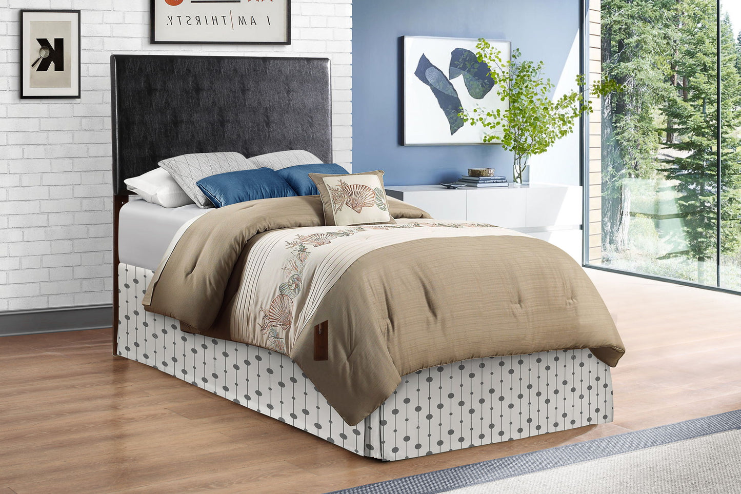 A modern bedroom with the Nova Headboard, a beige comforter, decorative pillows, patterned bed skirt, blue and white walls, framed art, a plant on a white dresser, and large windows overlooking trees.
