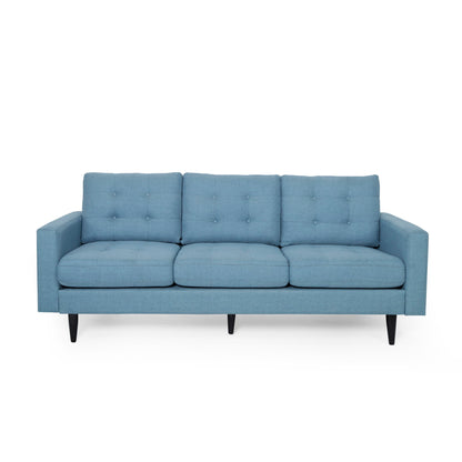 The Jenny Contemporary Tufted Fabric 3 Seater Sofa features a blue mid-century design with three seat and back cushions, button tufting, and angled black wooden legs.