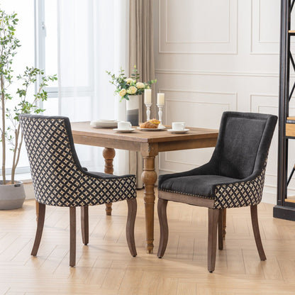 A bright, elegant room features a wooden dining table with dishes and pastries, flanked by two Ultra Side Dining Chairs—thickened fabric seats, neutral wood legs, bronze nail heads—plus large windows, plants, and a flower vase on the table.