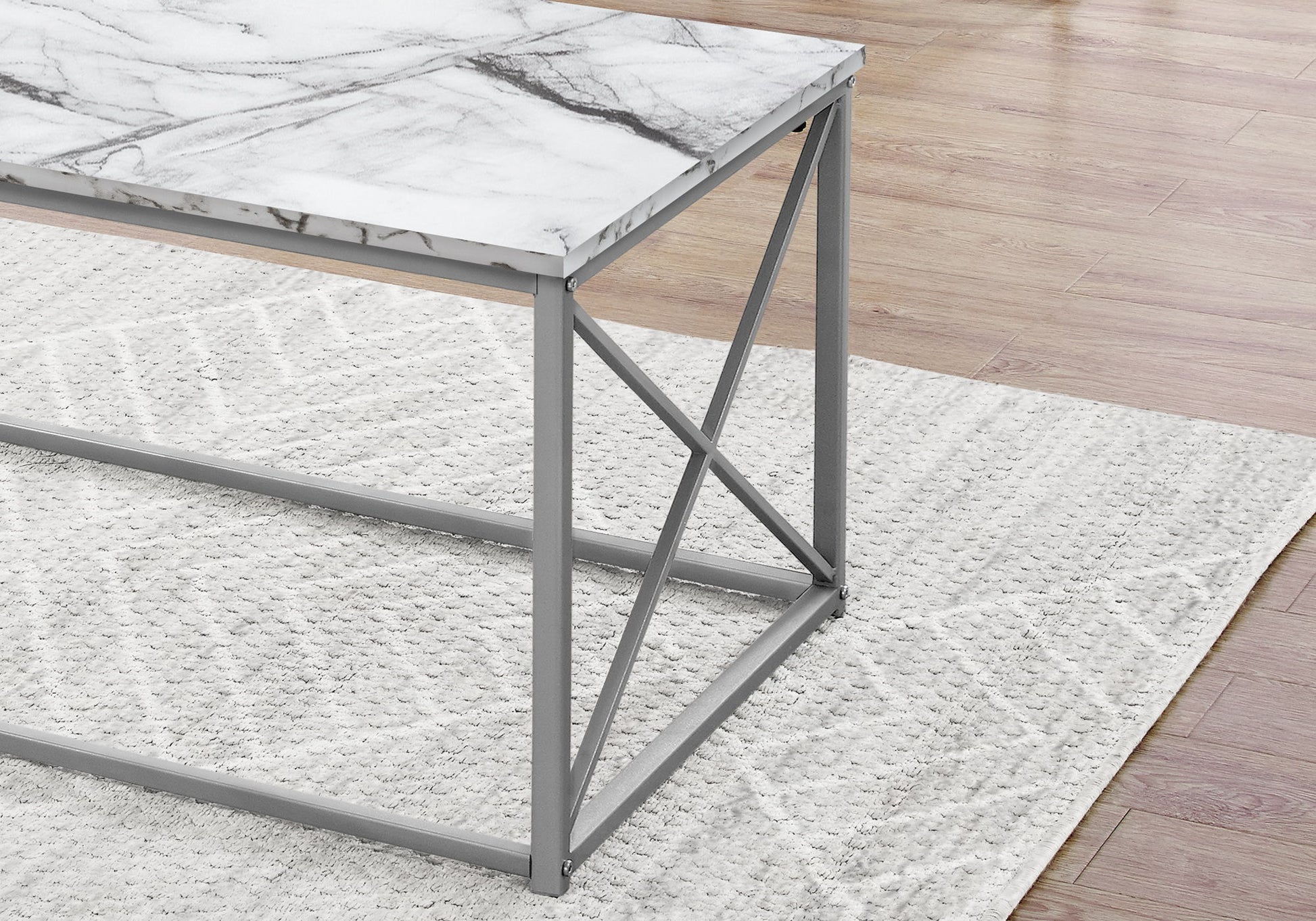 A close-up of the contemporary Table Set (coffee, end, and side) with a marble-look laminate top and gray metal frame, placed on a textured light gray rug over a wooden floor.