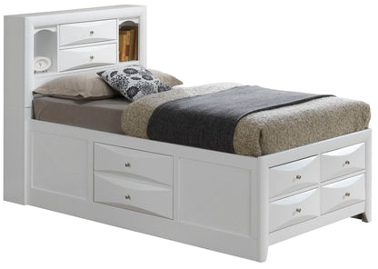 The Marilla Storage Bed With Bookcase Headboard features built-in storage drawers underneath and shelves in the headboard, topped with pillows, a patterned cushion, and neatly folded bedding.
