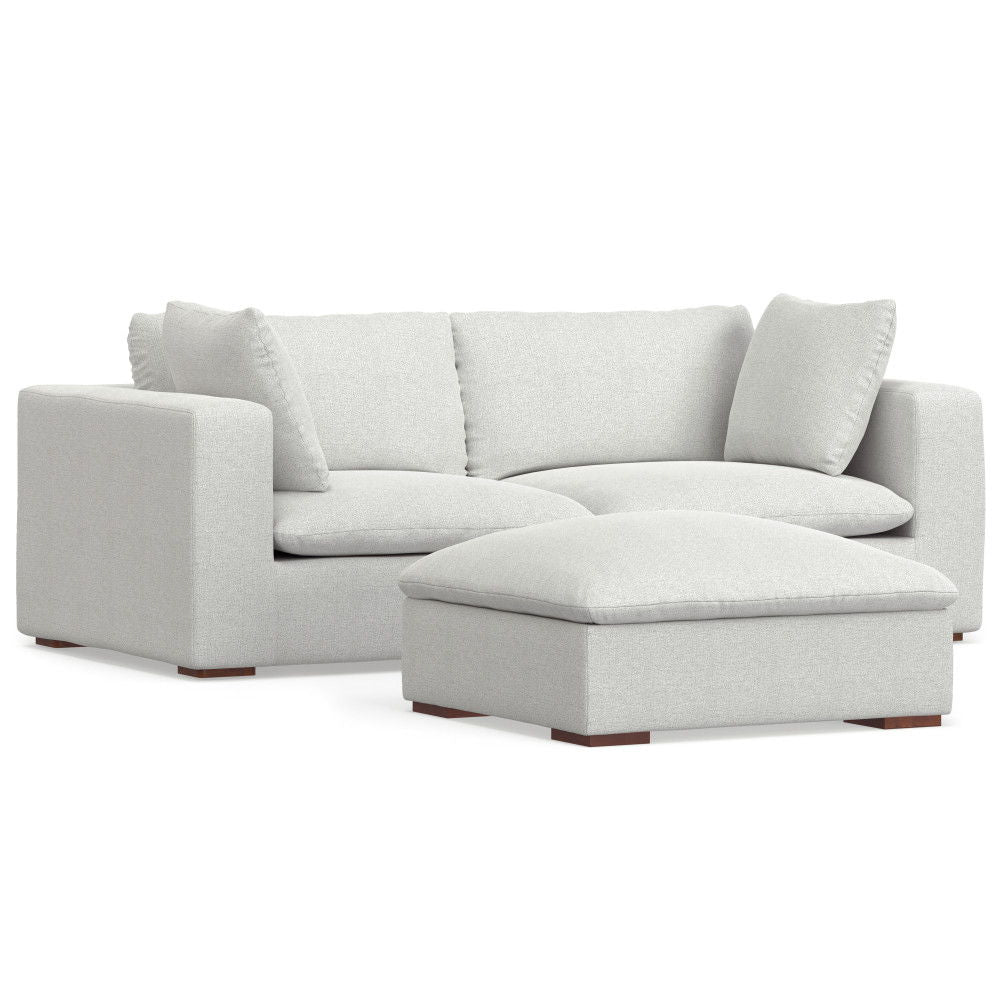 The Jasmine Handcrafted Sofa and Ottoman features modern light gray upholstery, three seat cushions, two back cushions, a matching rectangular ottoman, and low wooden block feet.