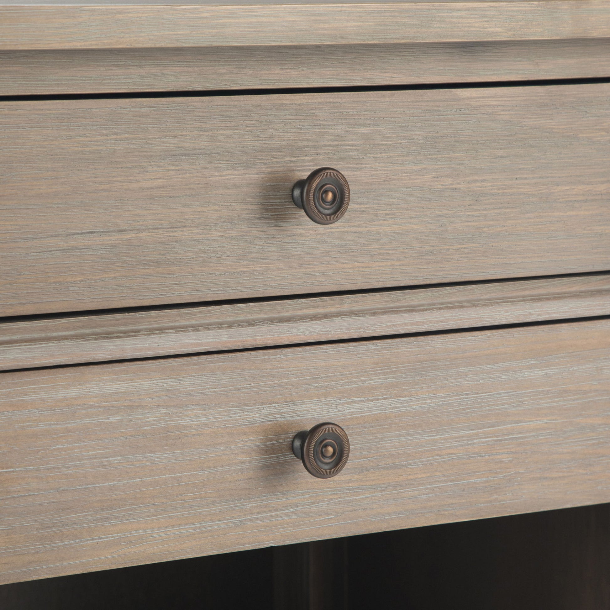 Close-up of the Carlton - Bedside Table, Handcrafted, showing two wooden drawers with round metal knobs. The light, weathered finish highlights horizontal grain patterns on the drawer fronts.