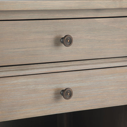 Close-up of the Carlton - Bedside Table, Handcrafted, showing two wooden drawers with round metal knobs. The light, weathered finish highlights horizontal grain patterns on the drawer fronts.