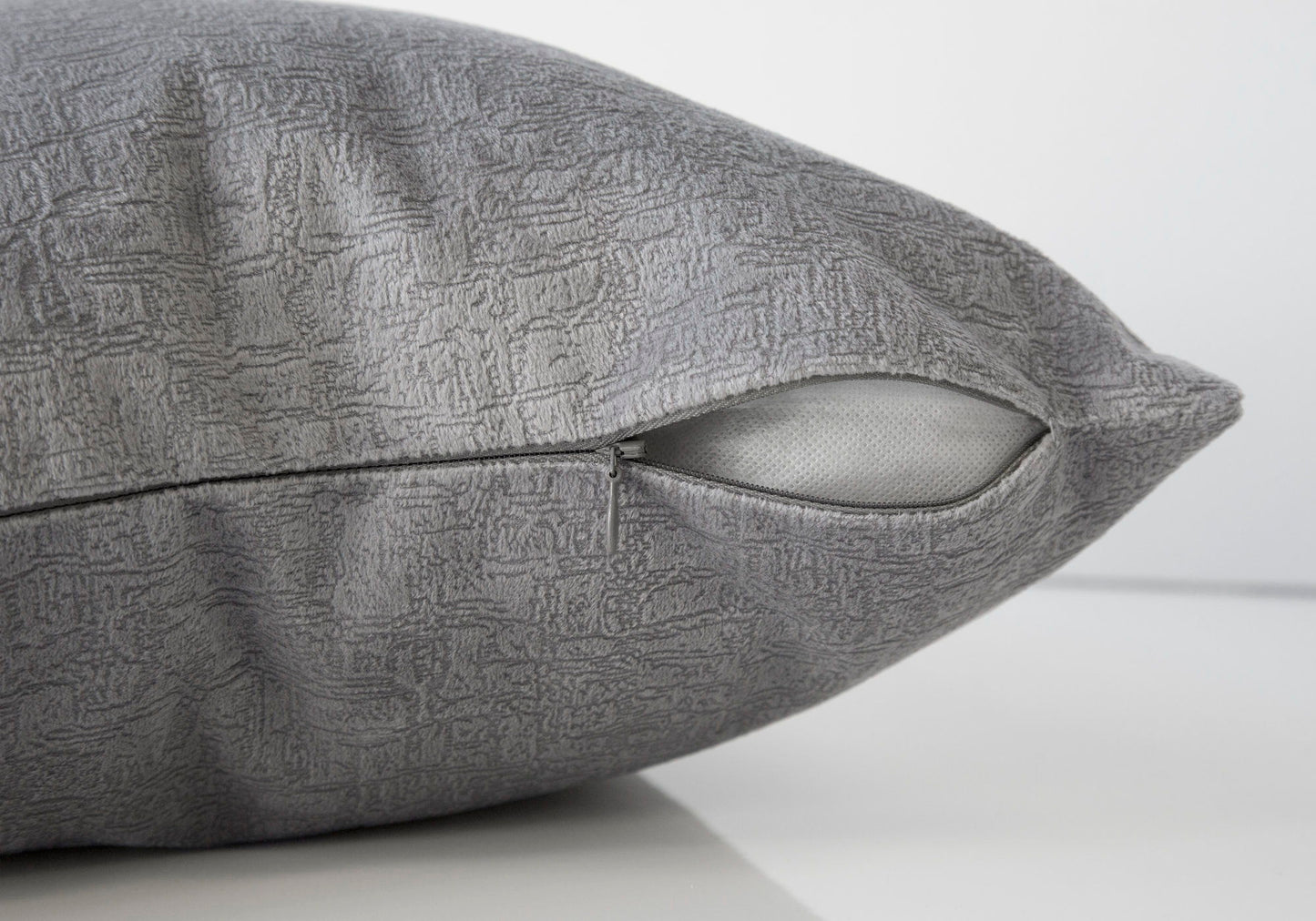 A close-up of the Pillow Square, Insert Included, Decorative Throw, Hypoallergenic shows its gray textured cover with a partially open zipper revealing the white insert against a plain white background.