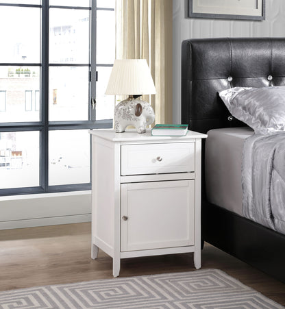 The Izzy 1 Drawer/1 Door Nightstand sits beside a black upholstered bed, topped with a white lamp, a decorative elephant, and a book. Large windows and beige curtains fill the modern bedroom with light.