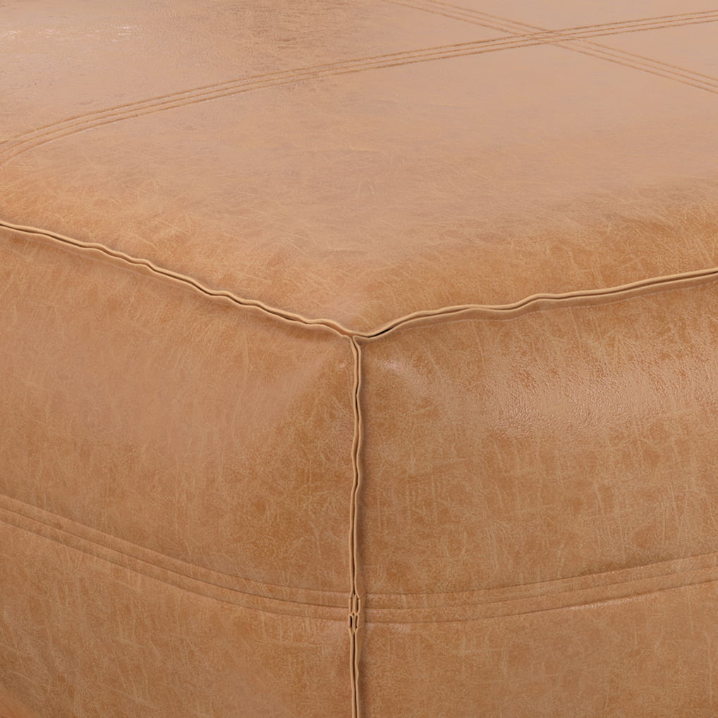 Close-up of the corner of the Brody Large Square Coffee Table Pouf in light brown leather, highlighting its visible stitching and subtle surface texture.