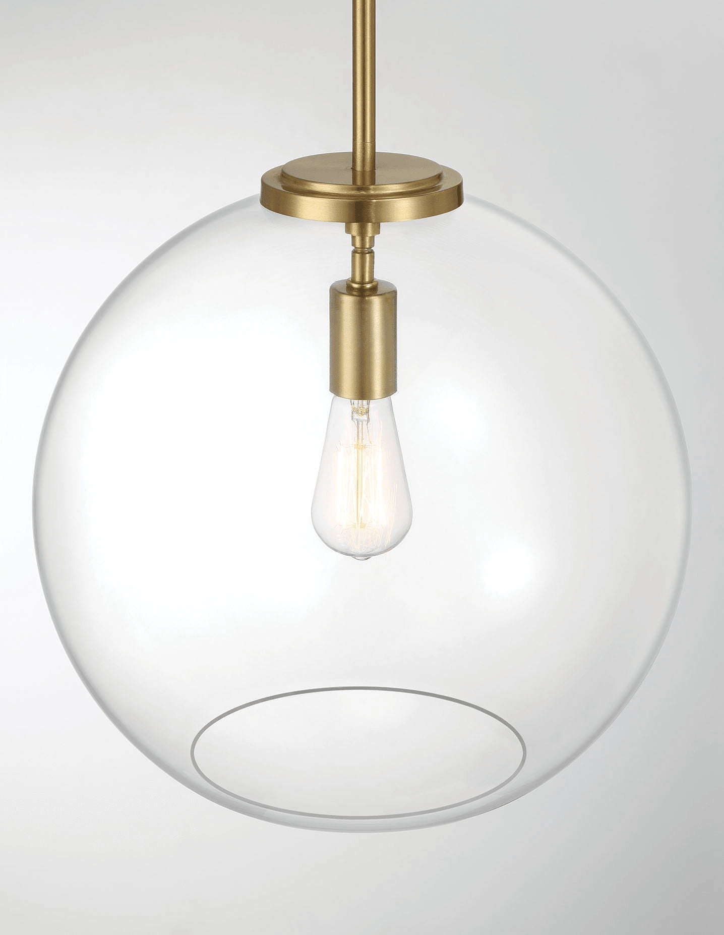 The Gleam Single Light Pendant Lamp features a gold, modern, minimalist design with an exposed filament bulb centered in a clear glass globe.