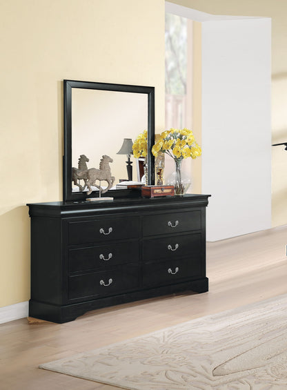 The Louis Philippe III dresser with six drawers stands against a beige wall. On top, a large mirror, horse figurines, table lamp, and a glass vase of yellow flowers add charm. A light rug covers the wooden floor.