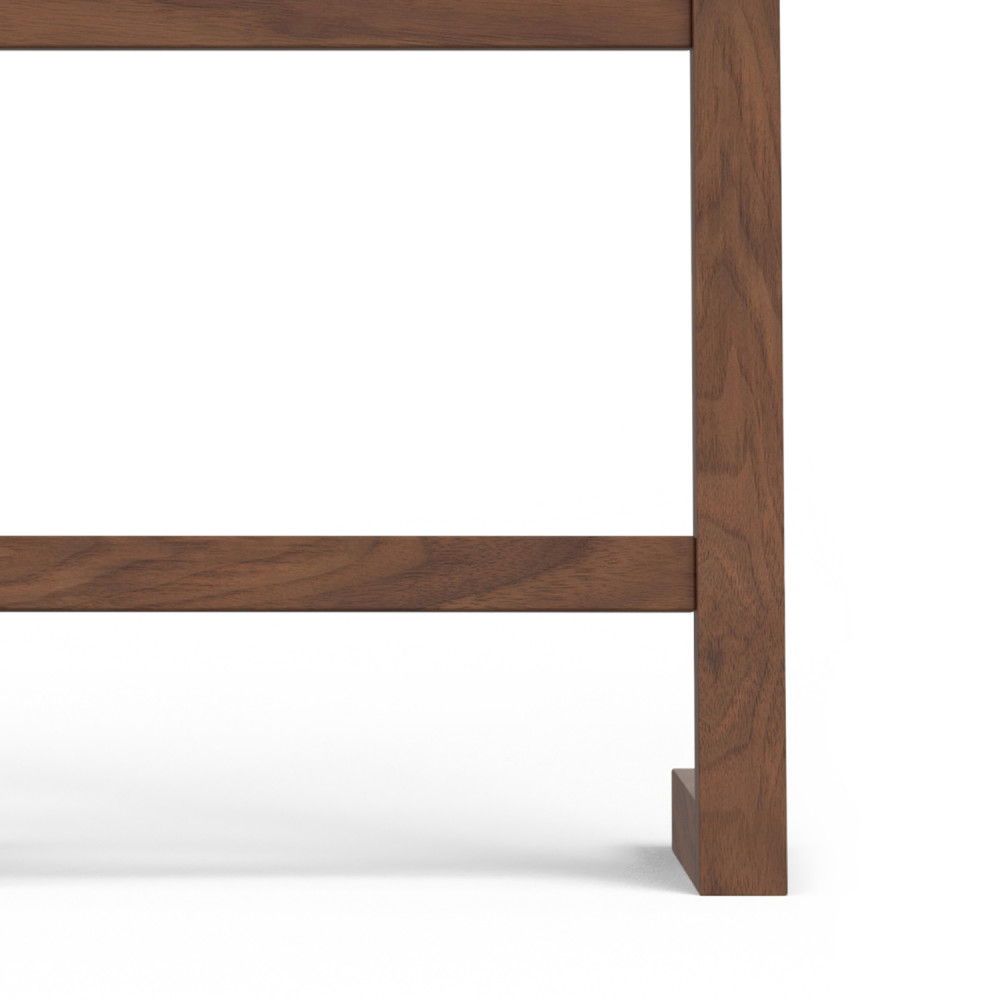 Close-up of the lower corner of the Bray Bath Towel and Blanket Ladder Shelf in Natural Walnut, showing its smooth brown finish and sturdy vertical and horizontal supports against a white background.