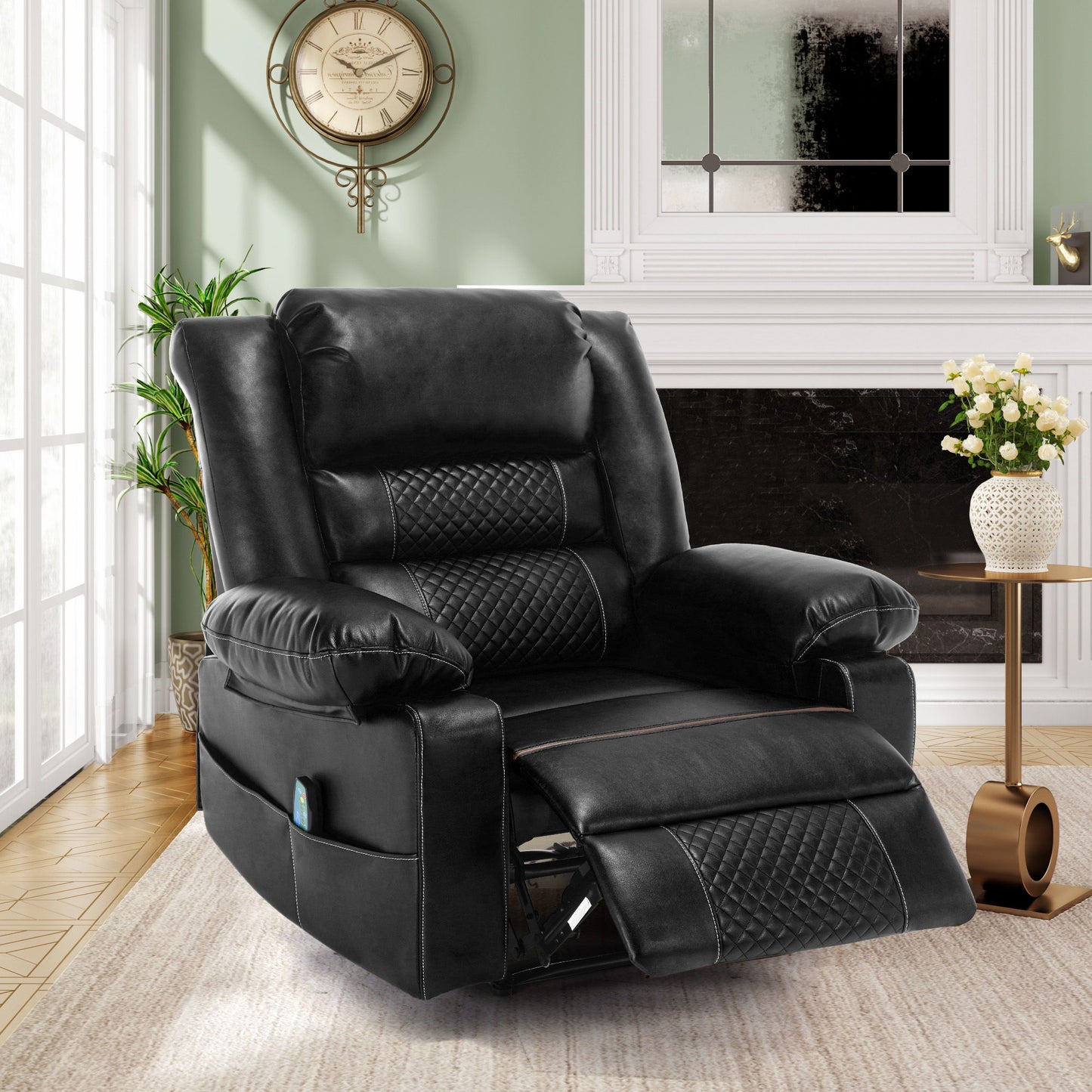 The Breathable Leather Massage Recliner Manual Chair, in black with quilted detailing, is placed in a bright living room by a window, facing a fireplace with fresh flowers, next to a round side table and under a decorative wall clock.