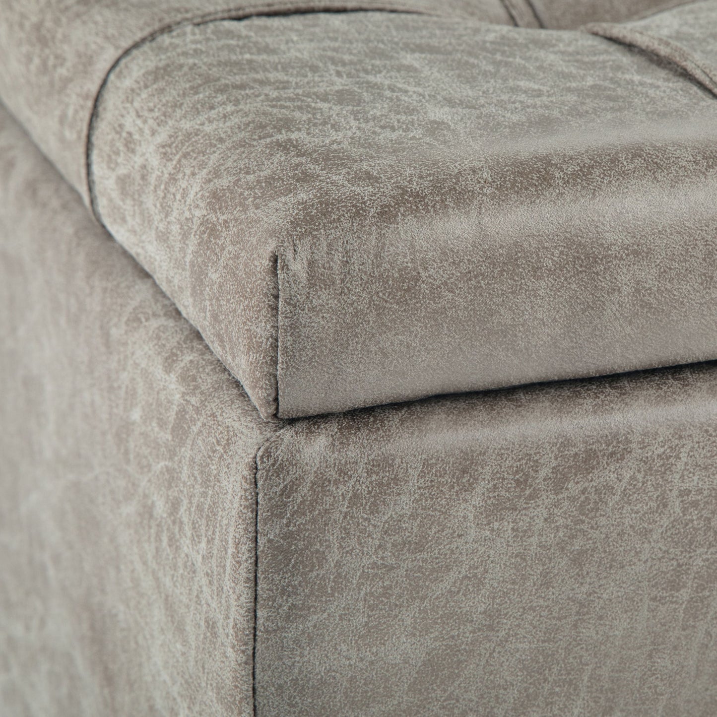 Close-up of the corner of the Harrison Upholstered Coffee Table Storage Ottoman in light gray, showing its textured fabric and detailed stitching.