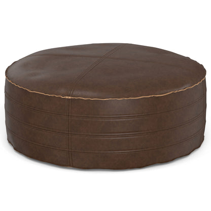 The Brody Round Pouf is a brown leather ottoman featuring visible stitching and subtle horizontal lines around its sides, displayed on a white background.