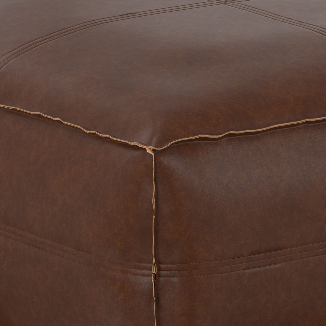 Close-up of the Brody - Large Square, Coffee Table Pouf highlighting its brown leather surface with detailed corner stitching and smooth texture.