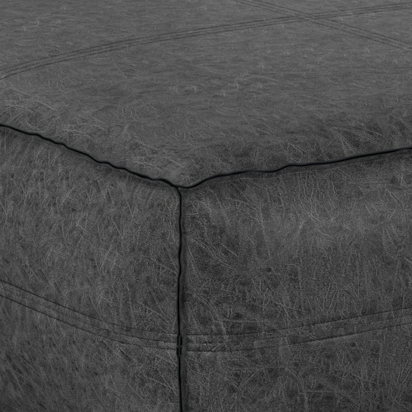 Close-up of the Brody - Large Square Coffee Table Pouf in dark grey leather, highlighting its corner with visible stitching and textured surface detail.