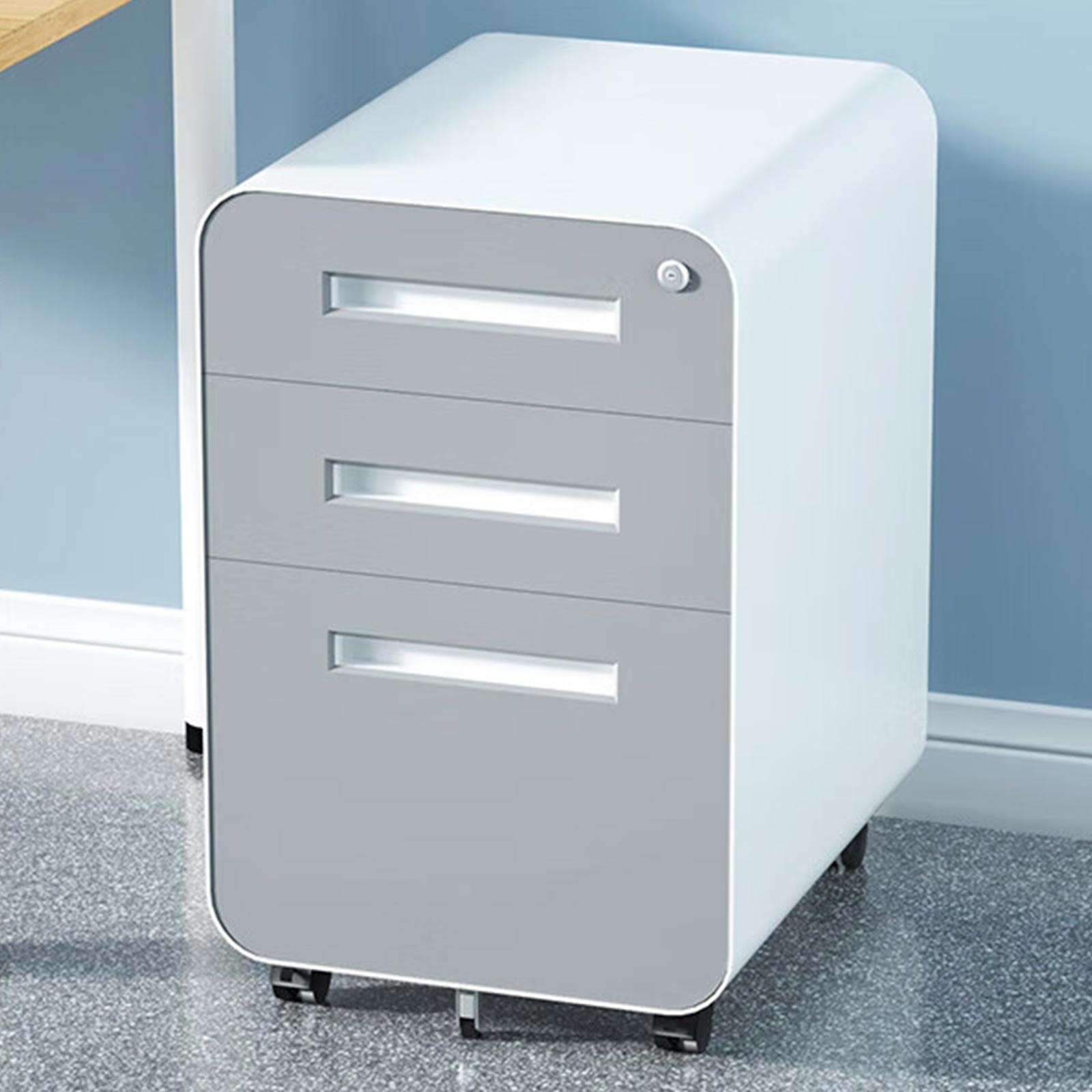 A 3 Drawer Mobile File Cabinet in gray and white cold rolled steel, with lock and 5-wheel anti-tilting design, sits next to a wooden desk on a speckled gray floor, against a blue wall. Suitable for legal/letter/A4 files; waterproof and moisture-proof.