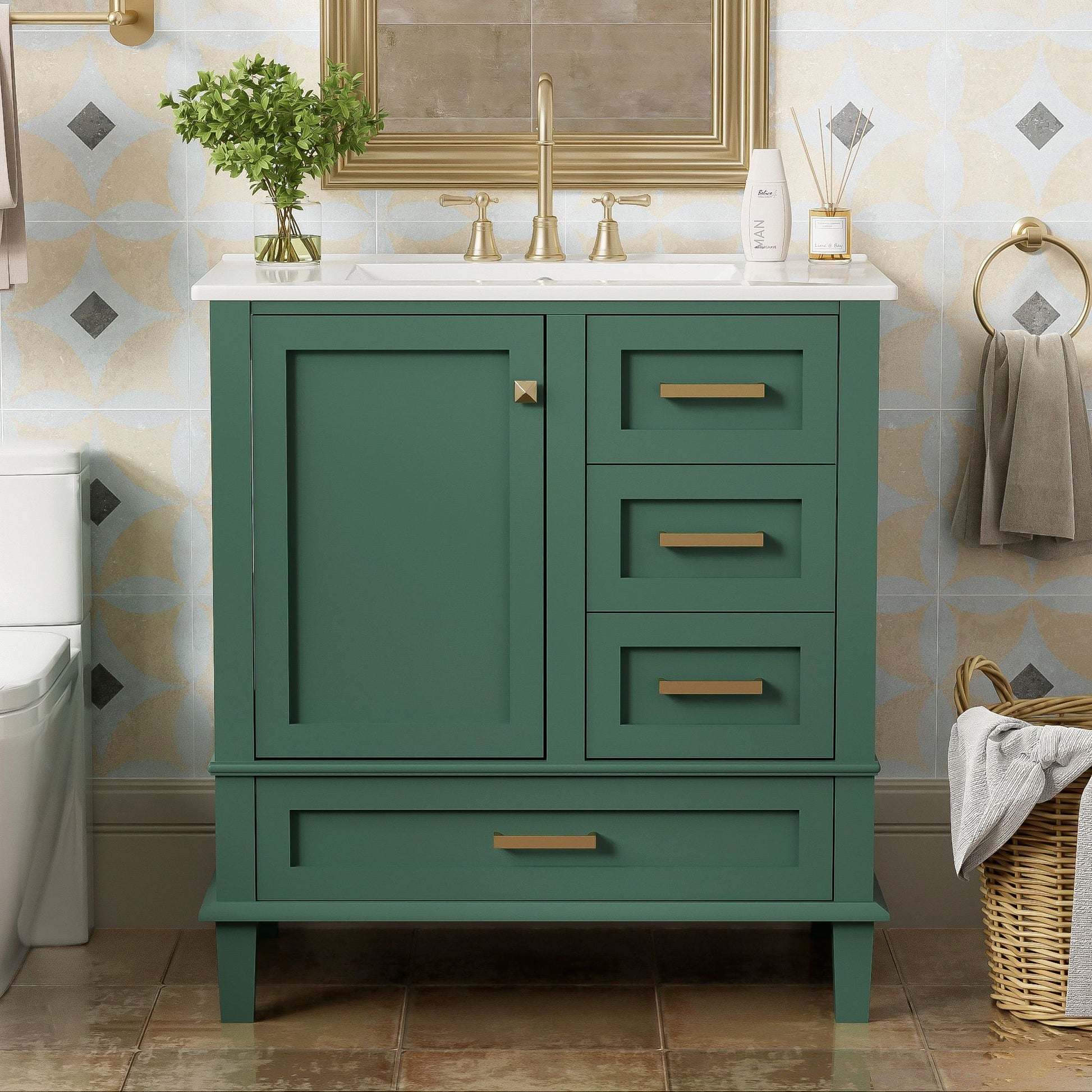 A modern bathroom vanity with a green cabinet, gold handles, white sink, and gold faucet features a solid wood frame, soft closing door, and 3 drawers. It stands on brown tile flooring with towels, a wicker basket, and a mirror above.