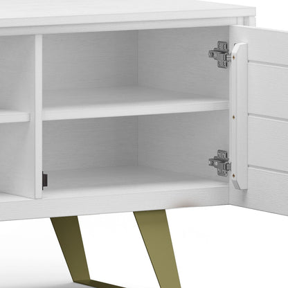 The Lowry Handcrafted TV Media Stand features a white wooden design with one open door showing two interior shelves, metal hinges, and stands on angled, gold-colored legs.