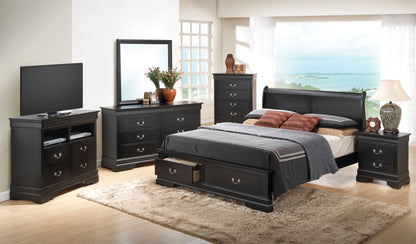 A modern bedroom features the Louis Phillipe Storage Bed with matching black wooden dressers and nightstands. A TV, mirror, lamps, and decor add style. Large windows showcase a water view, while a beige rug sits on the light wood floor.