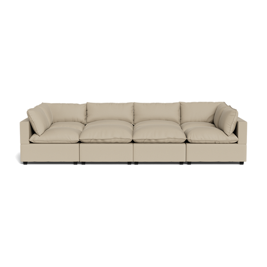 The Kova Pillow Cushion Grand Pit is a modern beige sectional sofa featuring plush seat and back cushions, four connected segments, and low square arms.