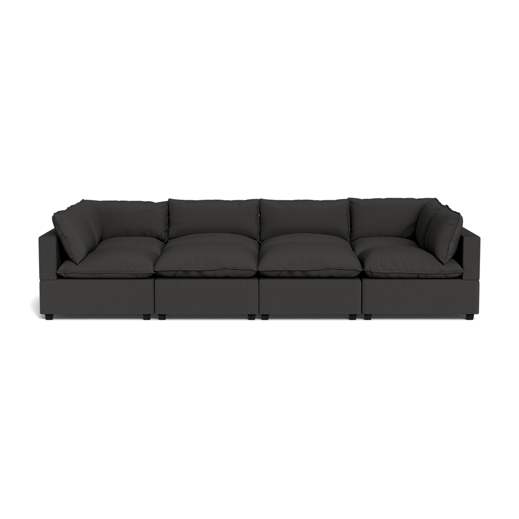 The Kova Pillow Cushion Grand Pit is a modern large black sectional sofa with four seat and back cushions, displayed against a black background.