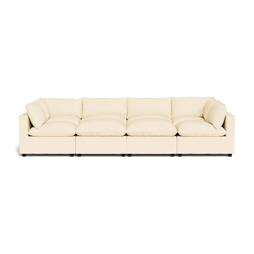 The Kova Pillow Cushion Grand Pit is a large, modern cream sectional sofa with four seat cushions and matching back and side pillows, shown from the front against a plain background.