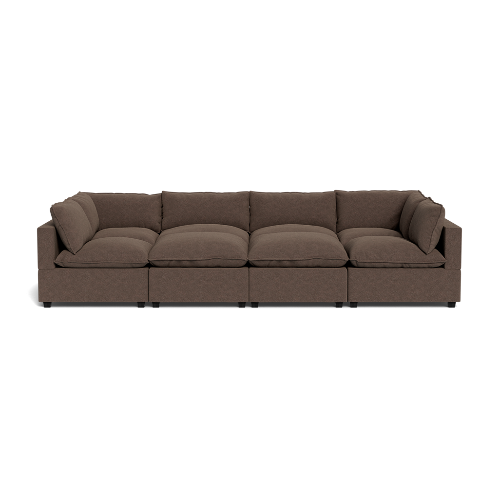 The Kova Pillow Cushion Grand Pit is a modern brown sectional sofa with six seat and six back cushions, low armrests, and a minimalist design, shown isolated on a white background.