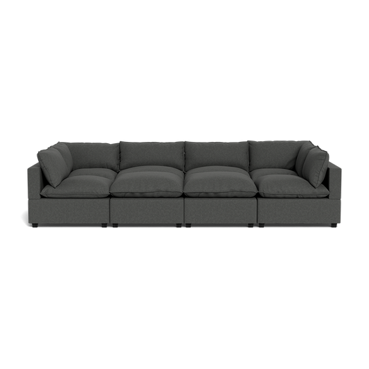 The Kova Pillow Cushion Grand Pit is a modern, dark gray sectional sofa with five seat and back cushions, shown from the front against a black background.