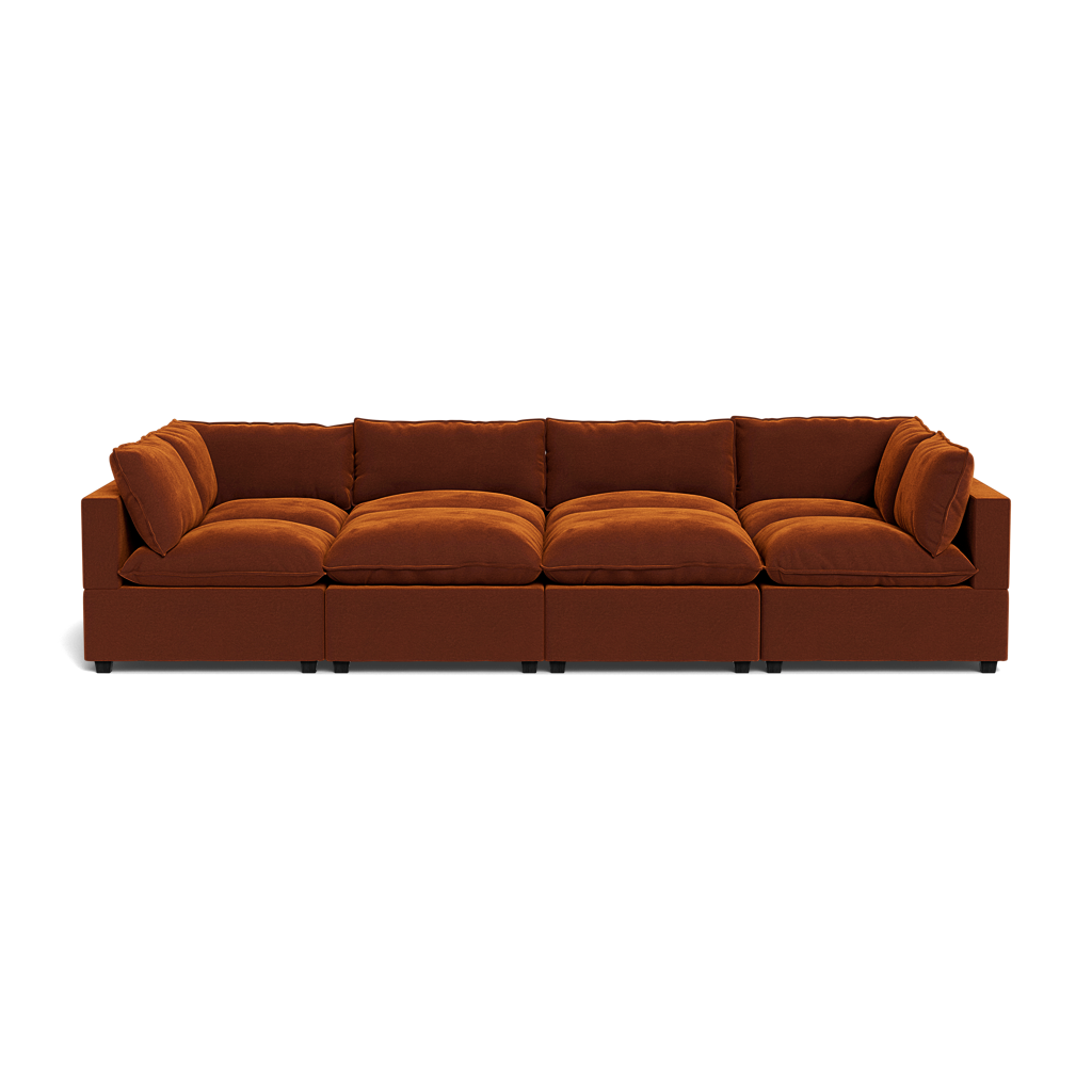 The Kova Pillow Cushion Grand Pit is a modern rust-colored sectional sofa featuring six cushioned seats and backrests, shown from the front against a plain background.