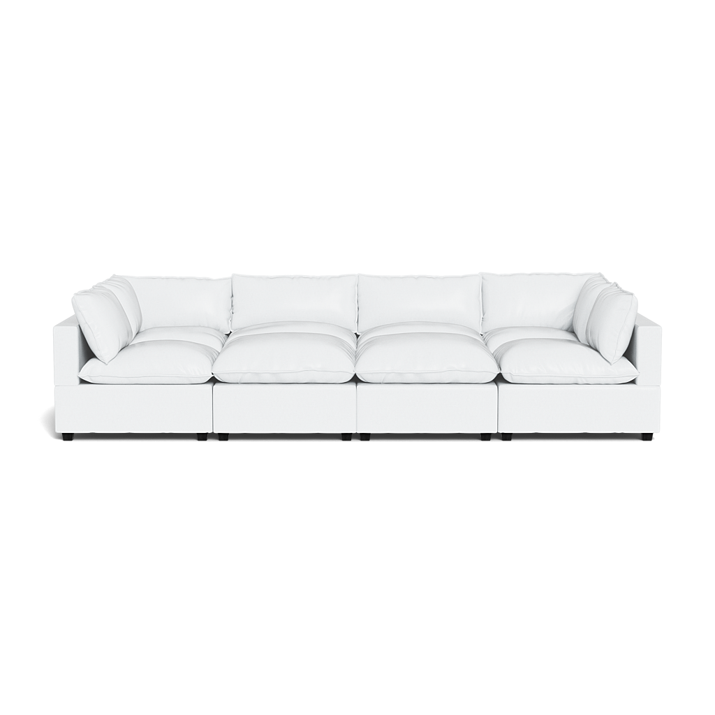 The Kova Pillow Cushion Grand Pit is a modern, long white sectional sofa with six seat cushions, six back cushions, clean lines, and low armrests.