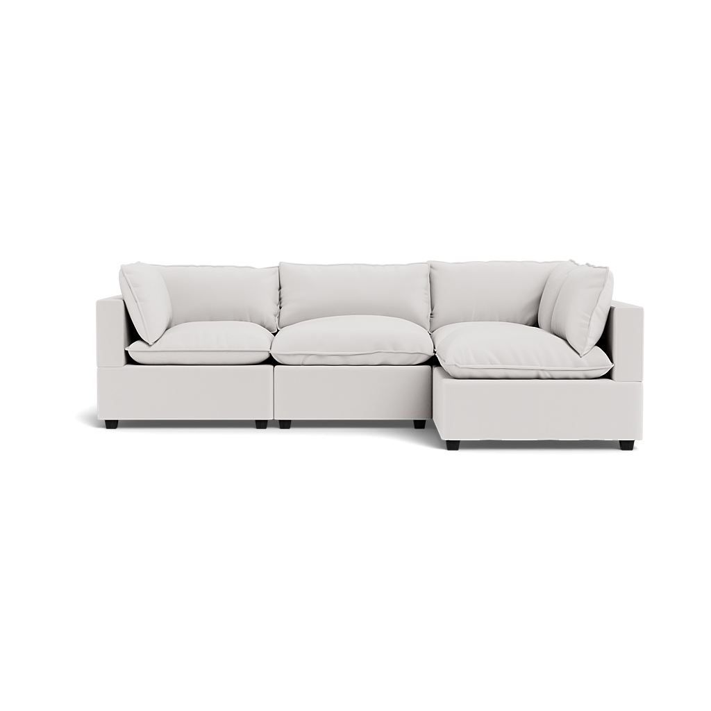 The Kova Pillow Cushion L-Shape is a modern, light gray sectional sofa with three seat cushions, four back cushions, and two armrests, photographed against a transparent background.