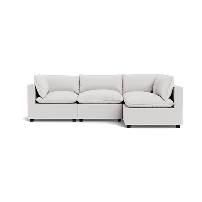 The Kova Pillow Cushion L-Shape is a modern, light gray sectional sofa with three seat cushions, four back cushions, and two armrests, photographed against a transparent background.