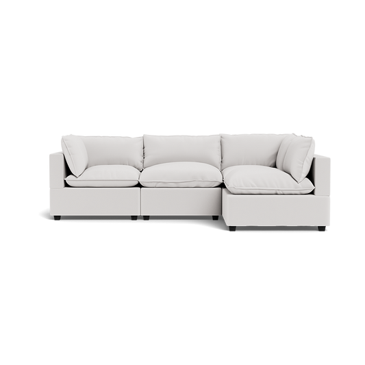The Kova Pillow Cushion L-Shape is a modern, light gray sectional sofa with three seat cushions, four back cushions, and two armrests, photographed against a transparent background.