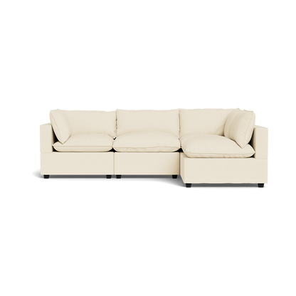 The Kova Pillow Cushion L-Shape is a modern, cream-colored sectional with three seat cushions, four back cushions, and armrests on both sides, shown from the front against a plain background.