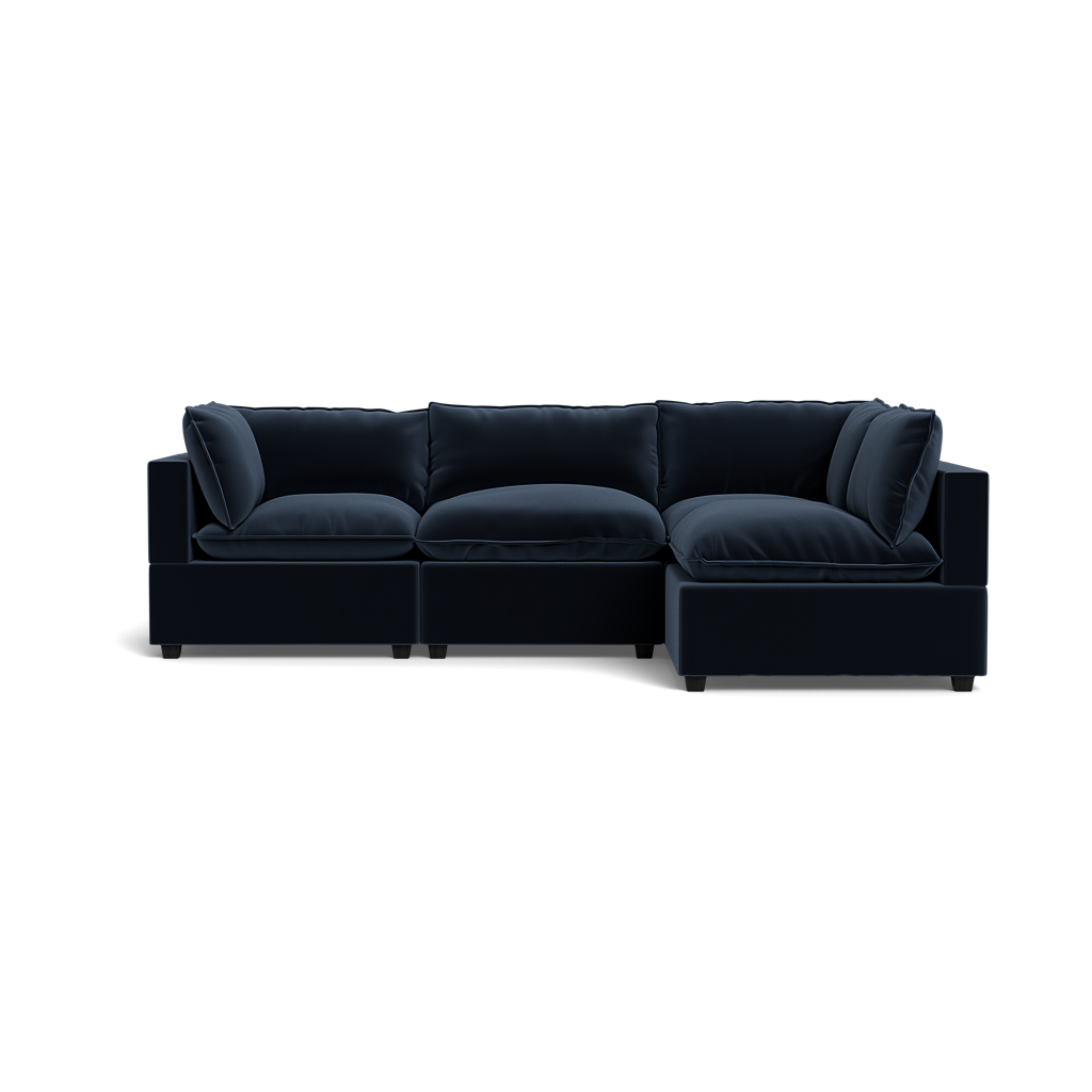 The Kova Pillow Cushion L-Shape is a modern dark navy blue sectional sofa with plush cushions and a right-side chaise, shown against a plain black background.