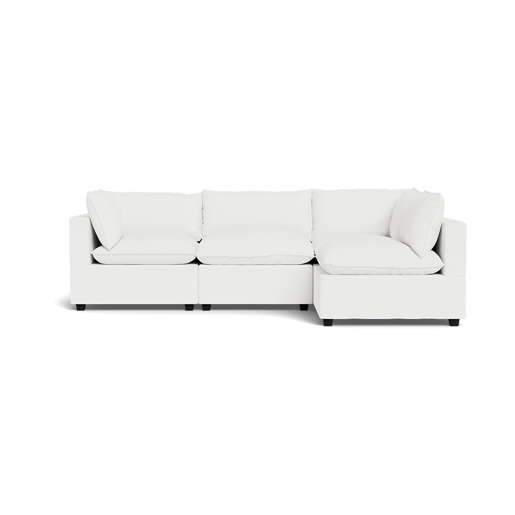 The Kova Pillow Cushion L-Shape is a modern white sectional sofa with three seat and back cushions, featuring a right-side chaise lounge, clean lines, and minimalist design, shown against a plain background.