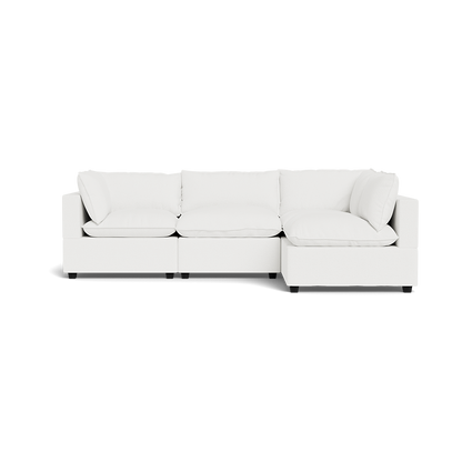 The Kova Pillow Cushion L-Shape is a modern white sectional sofa with three seat and back cushions, featuring a right-side chaise lounge, clean lines, and minimalist design, shown against a plain background.