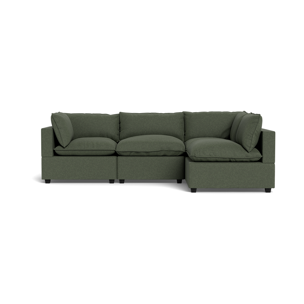 The Kova Pillow Cushion L-Shape is a modern, dark green sectional sofa with three seat cushions, three back cushions, and two armrests, shown from the front against a black background.