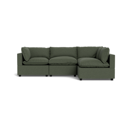 The Kova Pillow Cushion L-Shape is a modern, dark green sectional sofa with three seat cushions, three back cushions, and two armrests, shown from the front against a black background.