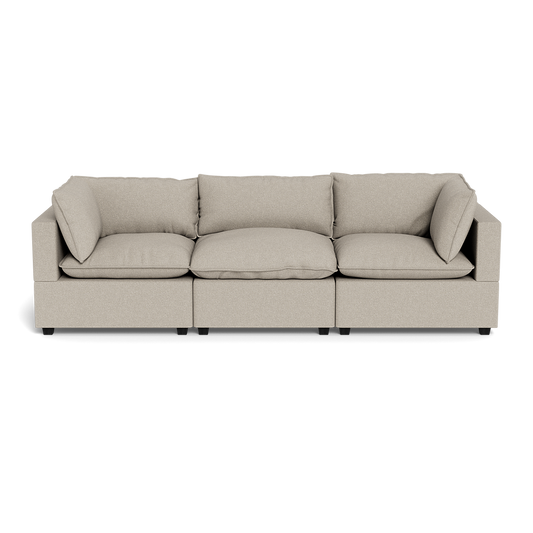 The Kova Pillow Cushion Sofa 122" is a modern beige three-seater with square arms and five matching cushions, shown from the front against a plain black background.