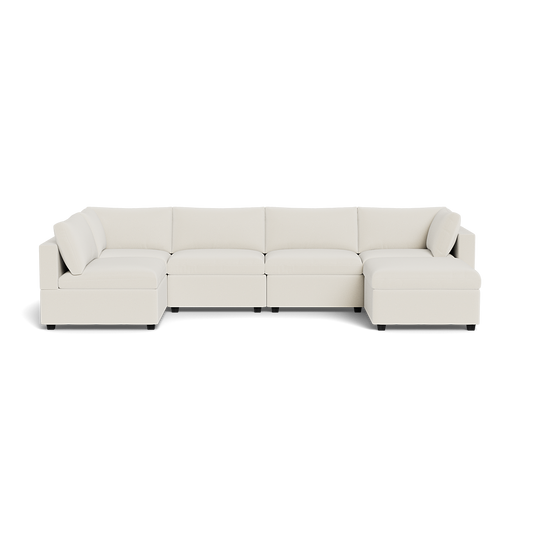 The Kova Box Cushion U-Shape is a modern, large cream-colored sectional sofa with a low backrest, wide seats, and chaise lounges at each end, shown from the front against a plain white background.